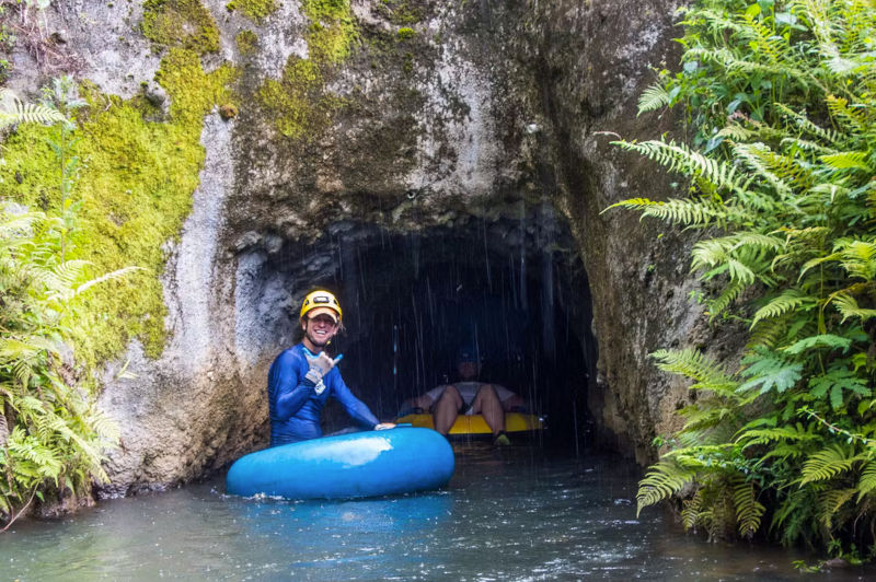 A tubing guide by a fern-covered tunnel entrance